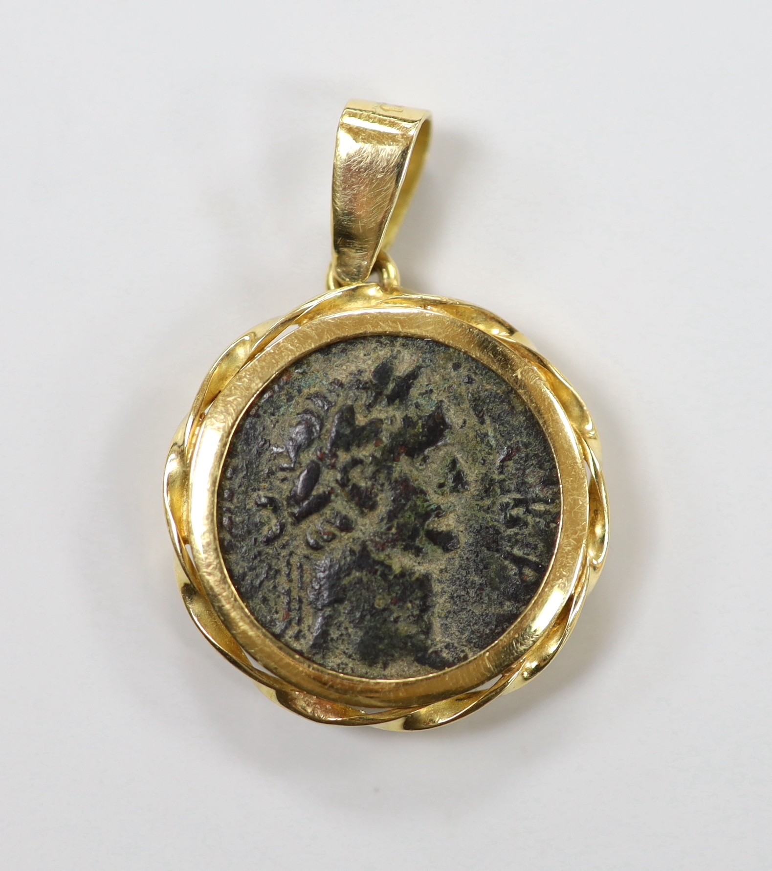 An ancient Roman bronze coin, now in an 18k pendant mount, diameter 21mm, gross weight 11 grams.
